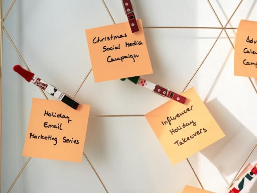 Orange sticky notes with notes about holiday marketing tactics